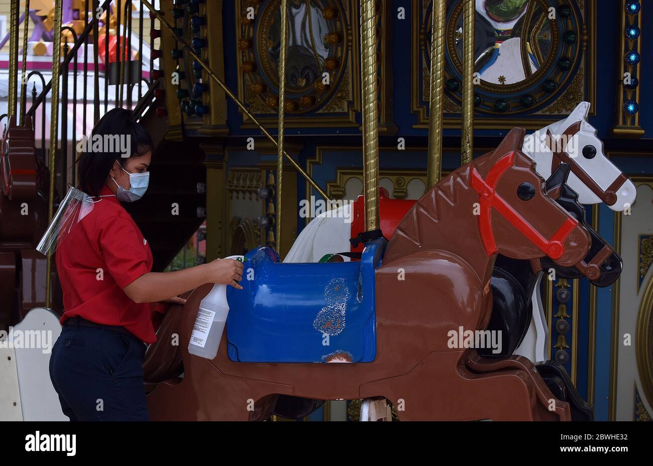 June 1, 2020 - Winter Haven, Florida, United States - An Employee disinfects the horses on the Grand Carousel ride at LEGOLAND Florida on the day the theme park reopened to the public after closing in mid-March due to the coronavirus pandemic. Guests are now required to submit to temperature checks and the wearing of face coverings is recommended but not required. (Paul Hennessy/Alamy Live News) Stock Photo