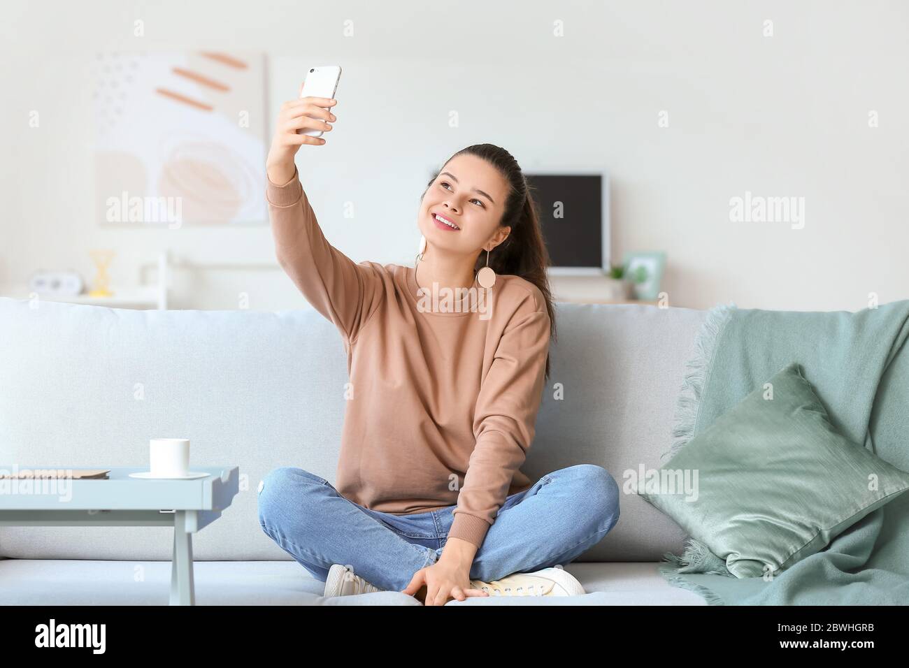 Beautiful young woman taking selfie at home Stock Photo - Alamy