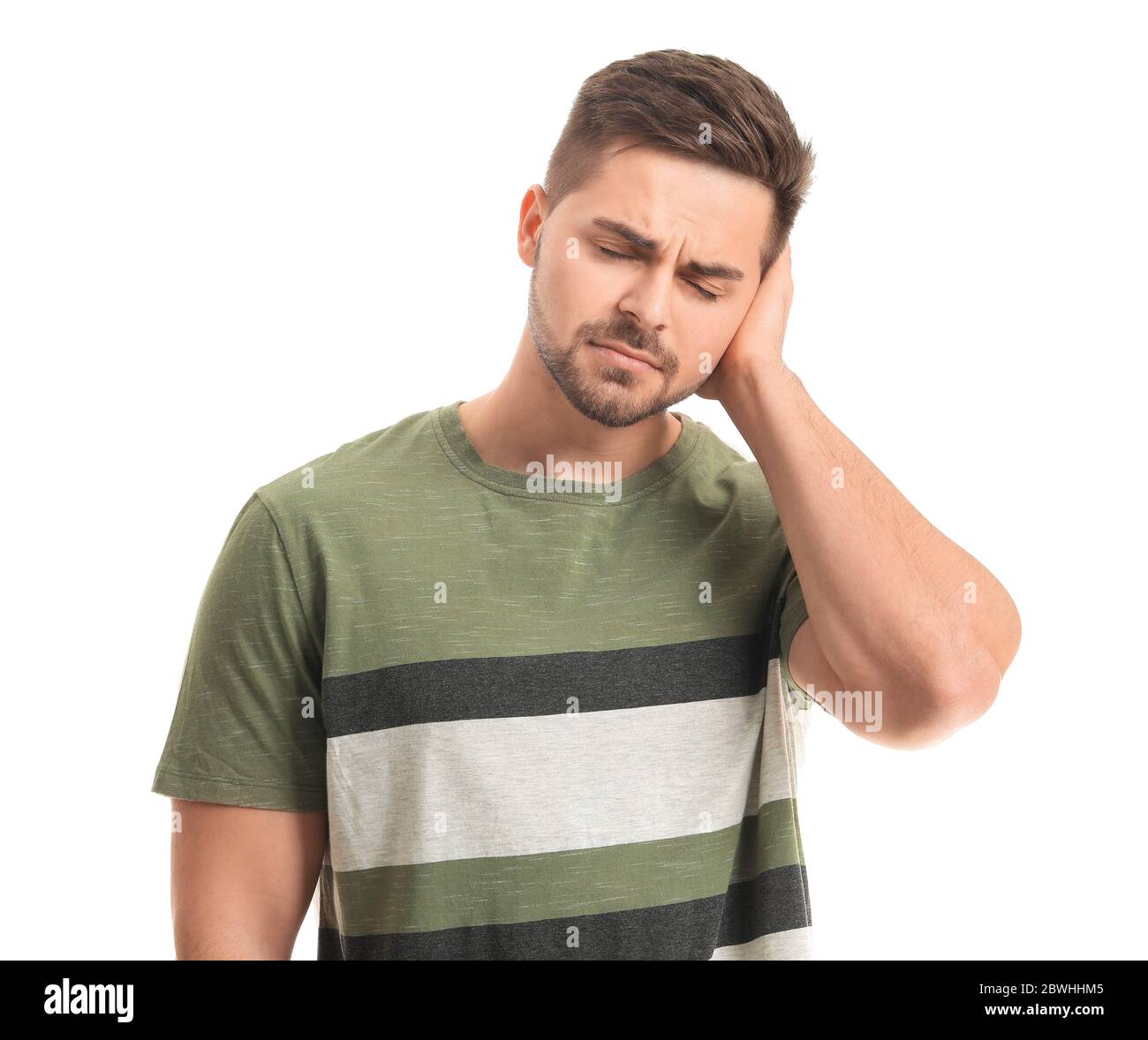 Young man suffering from loud noise on white background Stock Photo