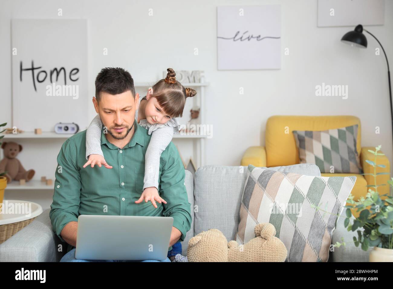 Working father with naughty little daughter at home Stock Photo