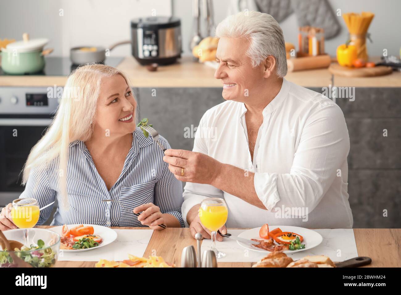 Happy elderly couple having breakfast at home Stock Photo