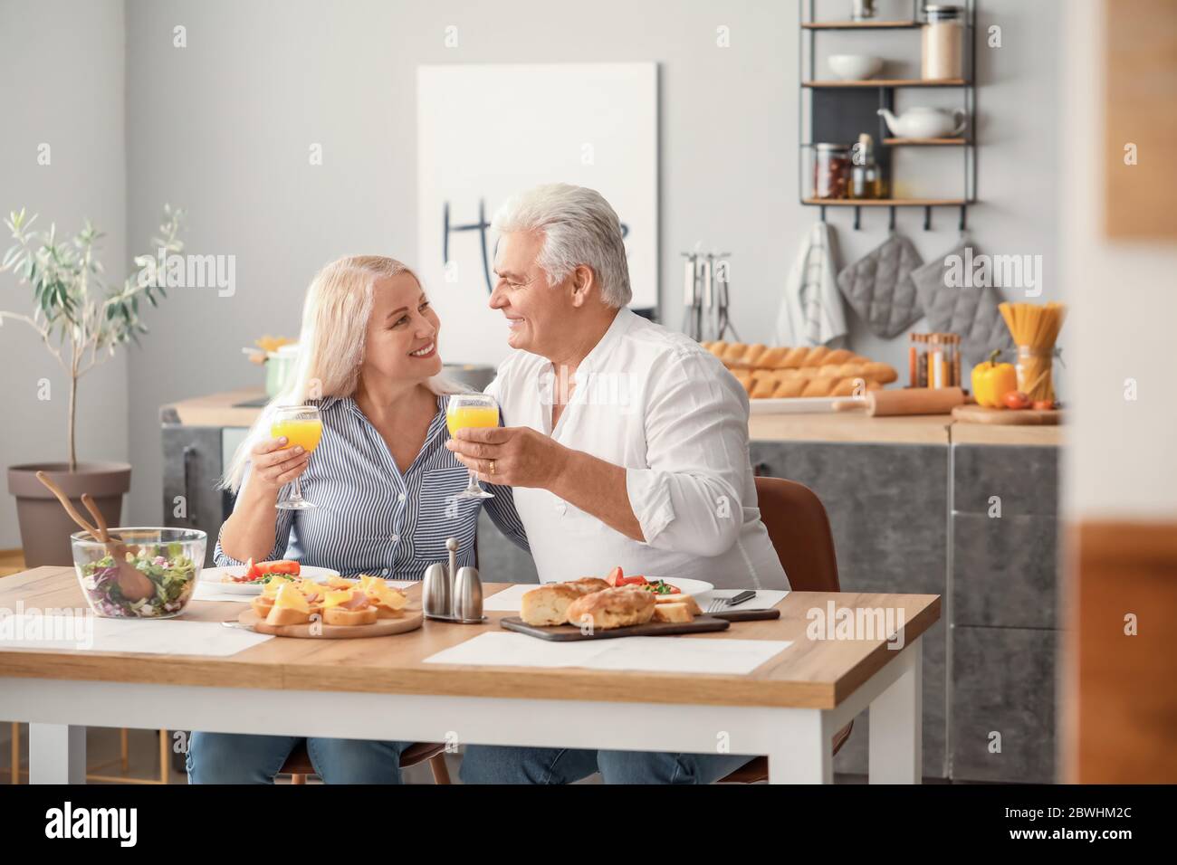 Happy elderly couple having breakfast at home Stock Photo
