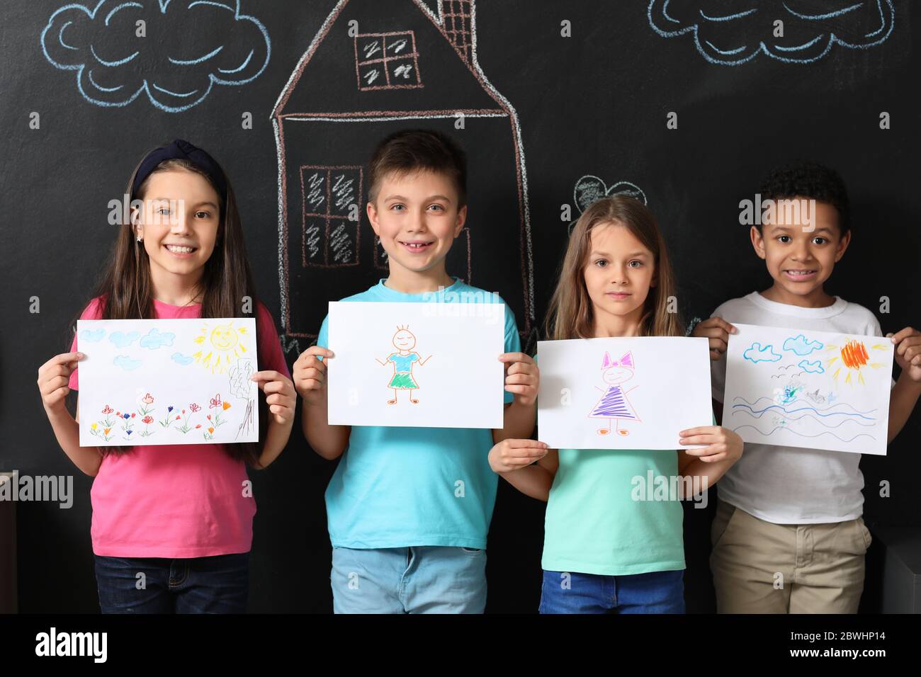 Cute children with drawings at school Stock Photo - Alamy