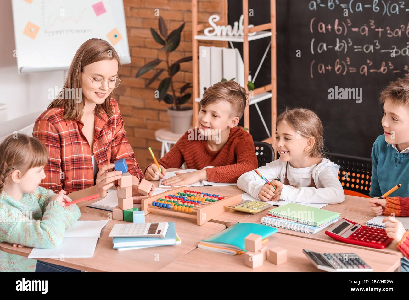 Children with math teacher during lesson in classroom Stock Photo - Alamy