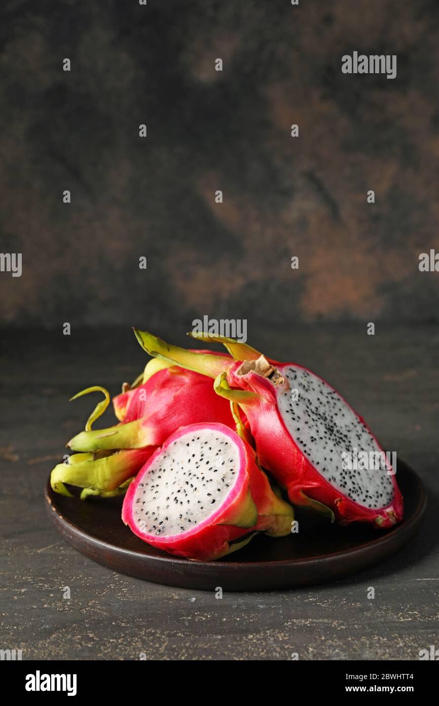 Plate with tasty dragon fruit on dark background Stock Photo
