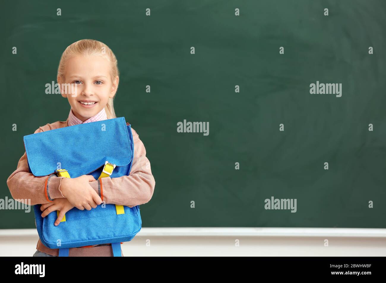 Cute little schoolgirl in classroom Stock Photo - Alamy