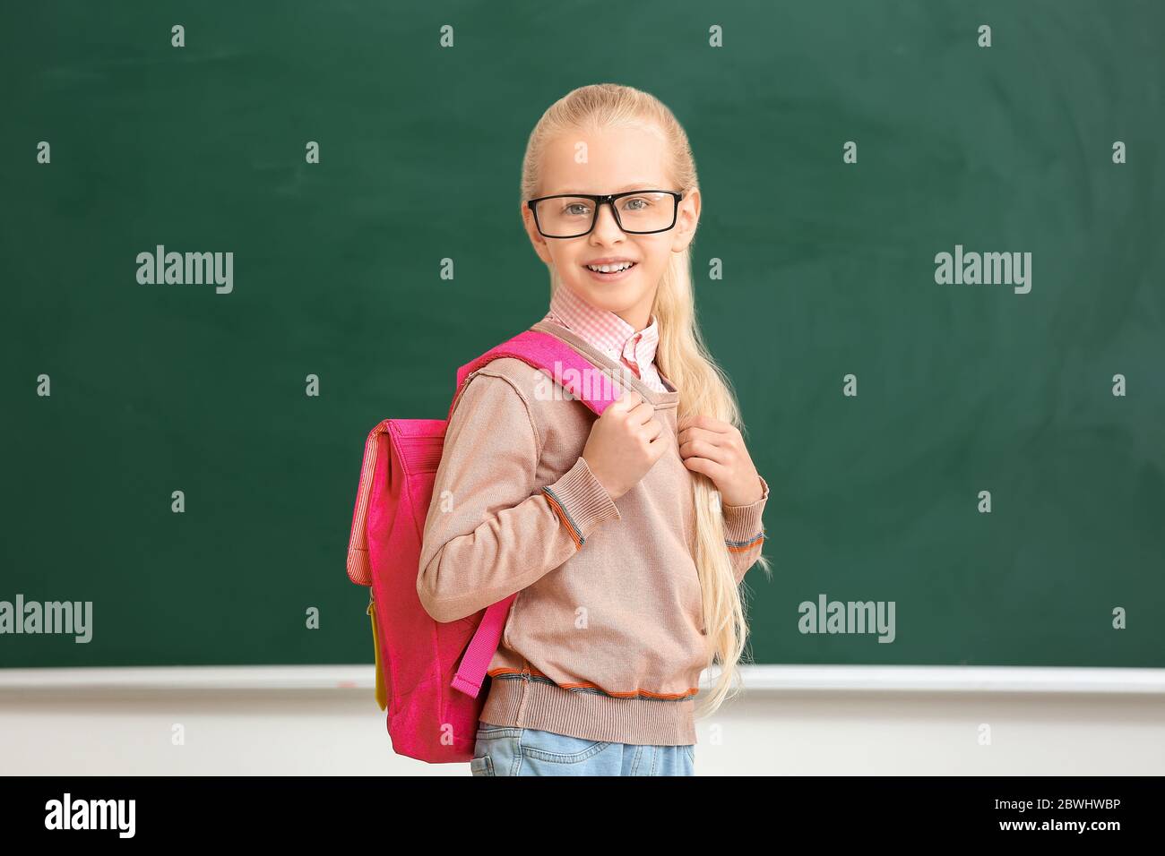 Cute little schoolgirl in classroom Stock Photo - Alamy