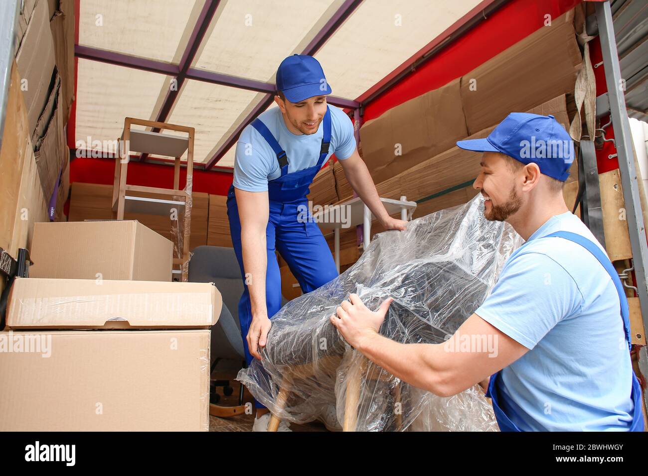 Loaders taking furniture from truck Stock Photo Alamy