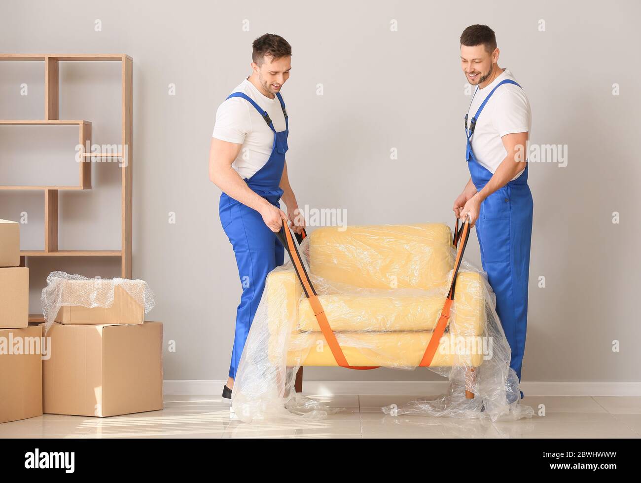 Loaders carrying furniture in flat Stock Photo Alamy