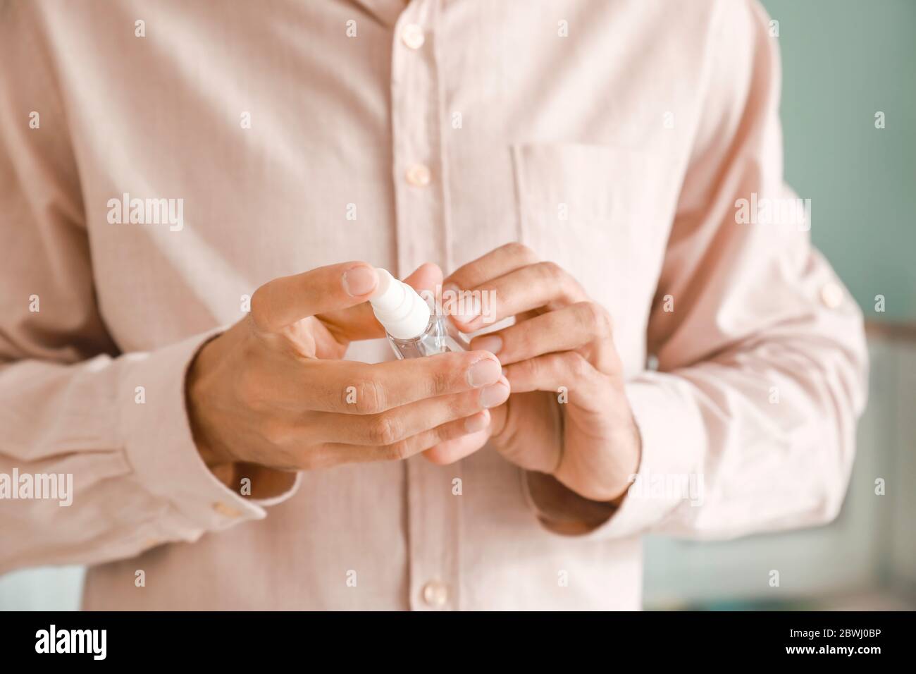 Man with disinfectant at home, closeup Stock Photo