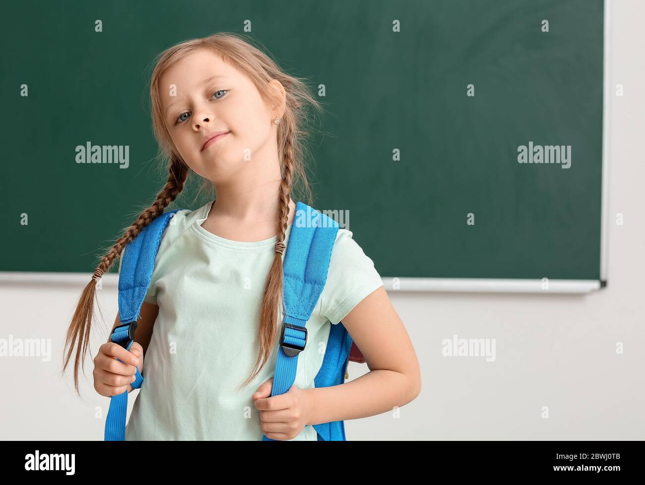 Cute little schoolgirl in classroom Stock Photo - Alamy