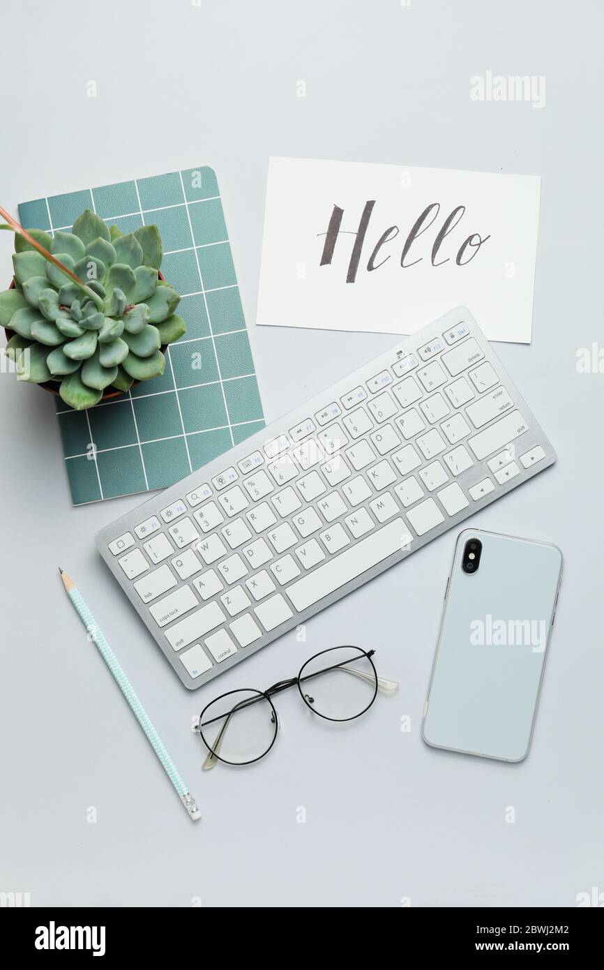 Computer keyboard with notebook, mobile phone and eyeglasses on white background Stock Photo