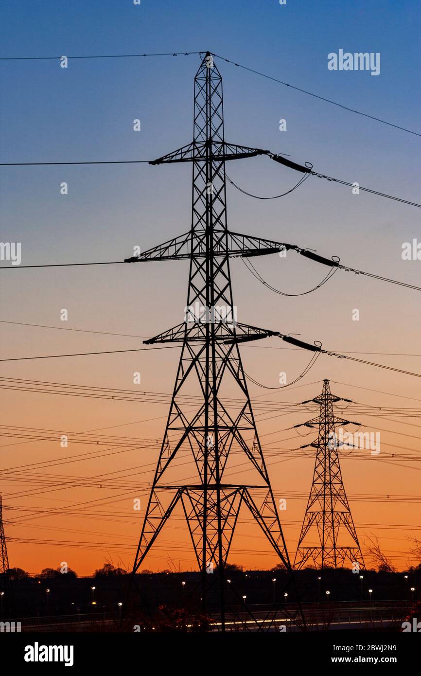 Electricity pylon in silhouette at dusk Stock Photo