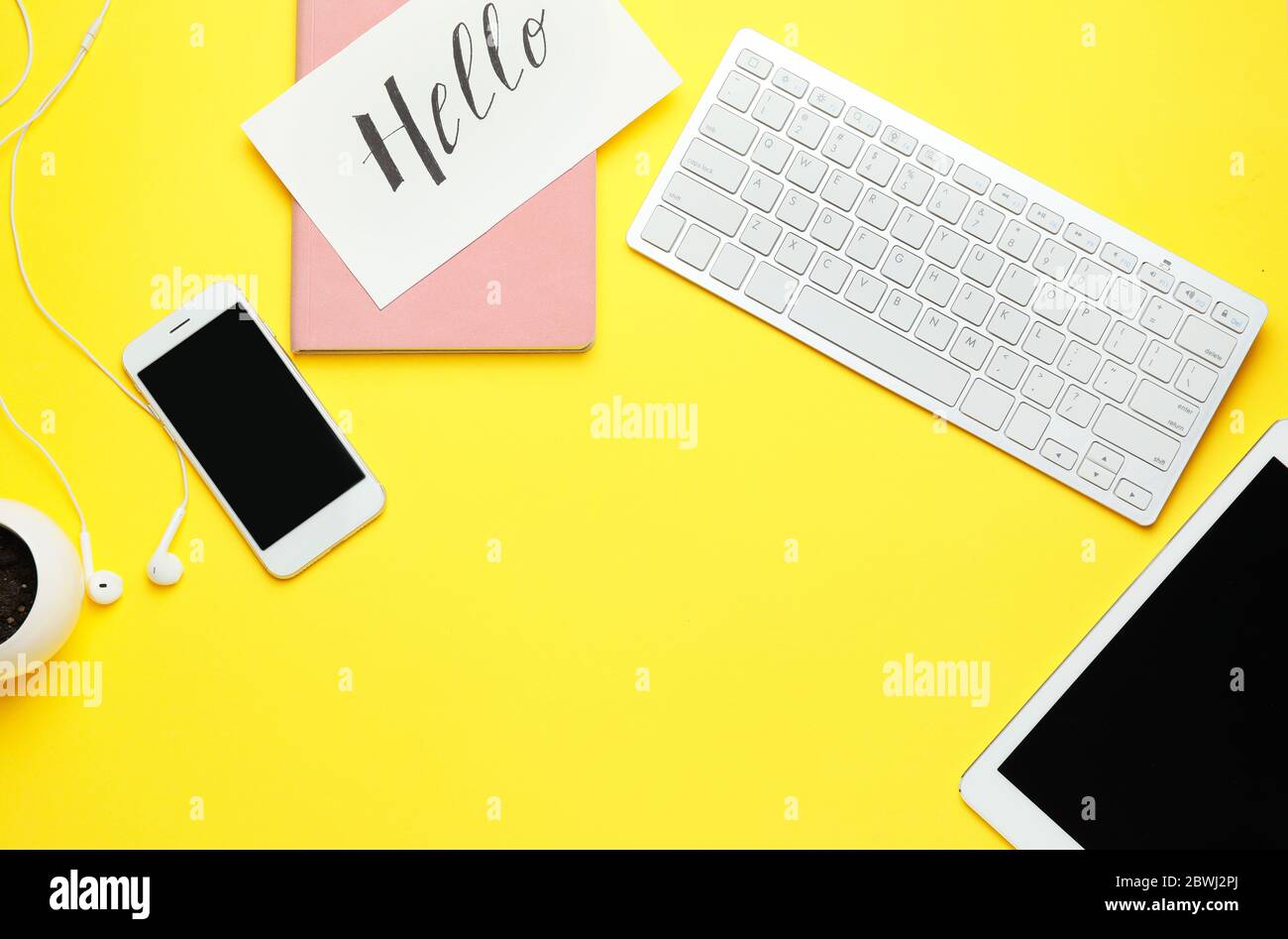 Computer keyboard with tablet PC, mobile phone and notebook on color background Stock Photo