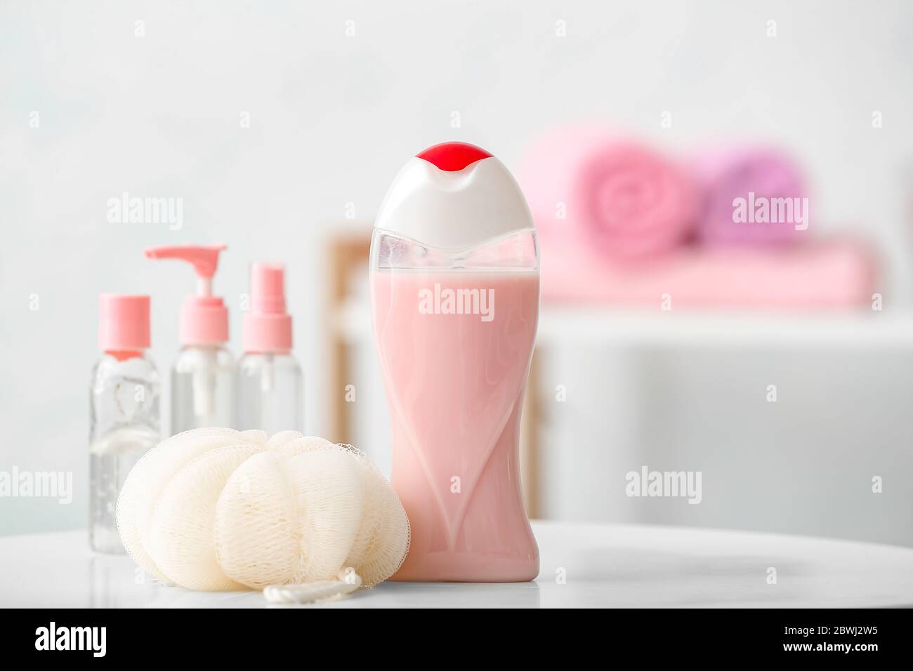 Different shower gels and loofah on table in bathroom Stock Photo Alamy