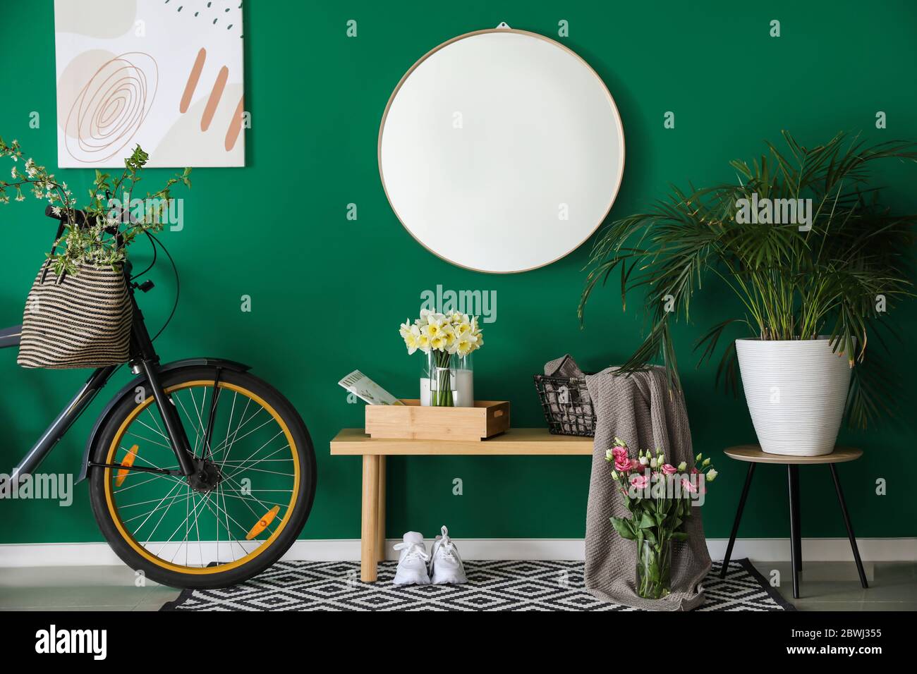 Interior of hall with stylish mirror and spring flowers Stock Photo - Alamy