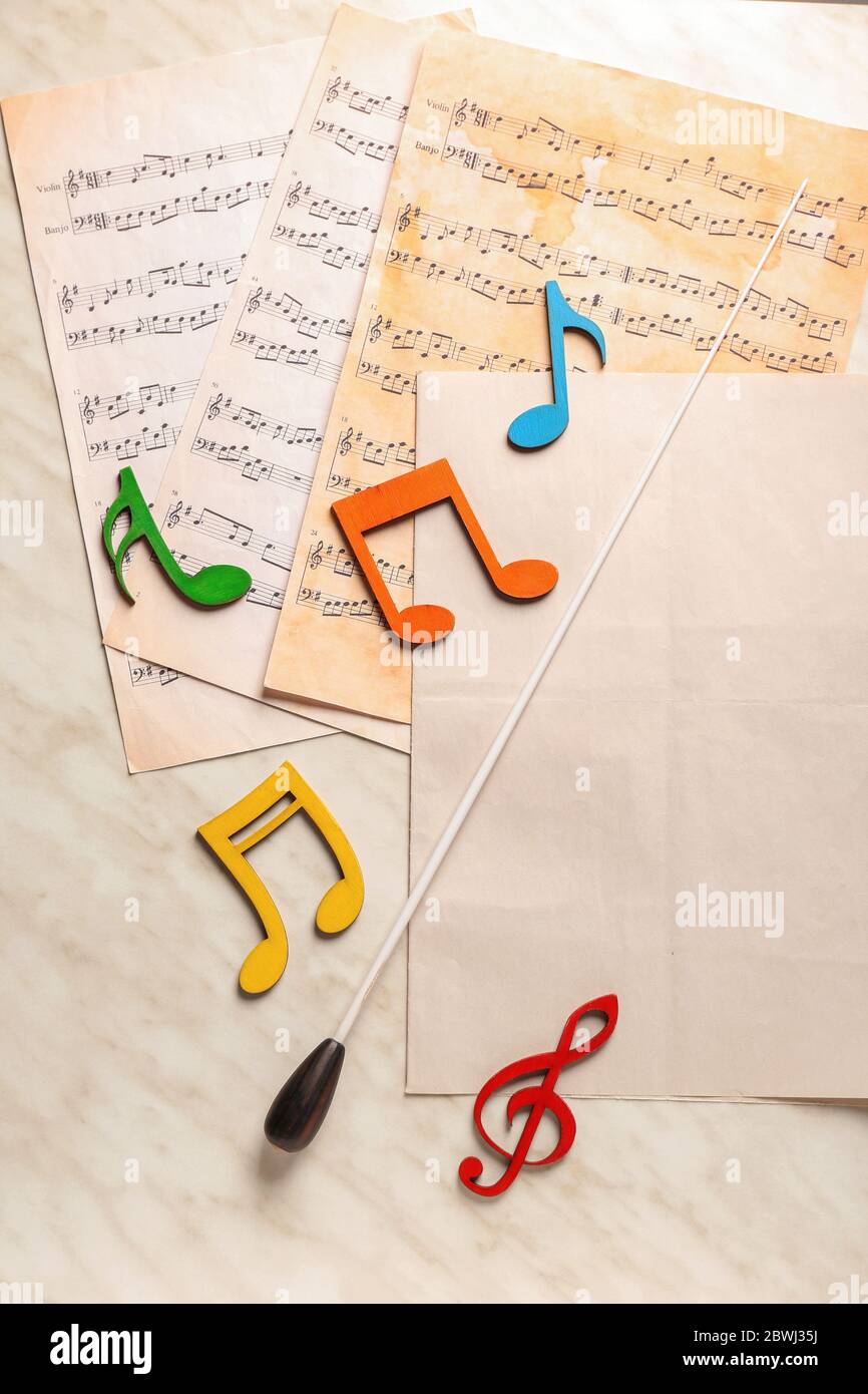 Note sheets and conductor's stick on light background Stock Photo Alamy