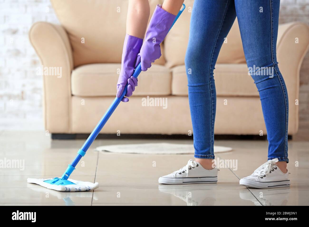Woman mopping floor in room Stock Photo