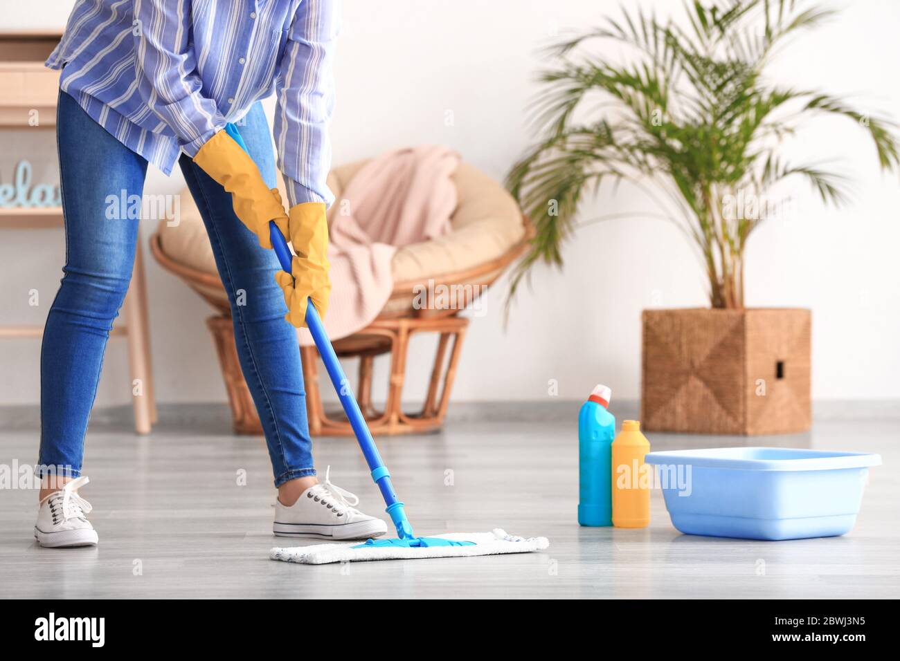 Woman mopping floor in room Stock Photo