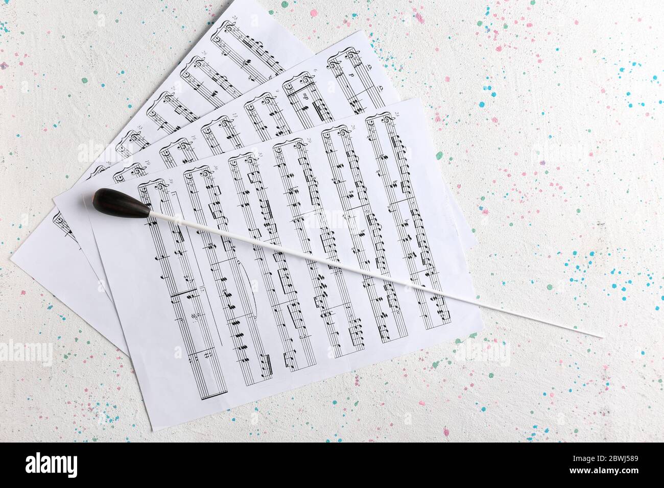Note sheets and conductor's stick on light background Stock Photo Alamy