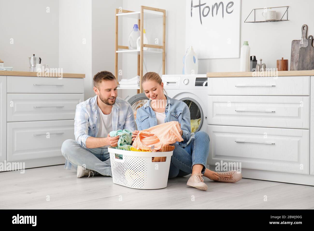 Happy couple doing laundry at home Stock Photo