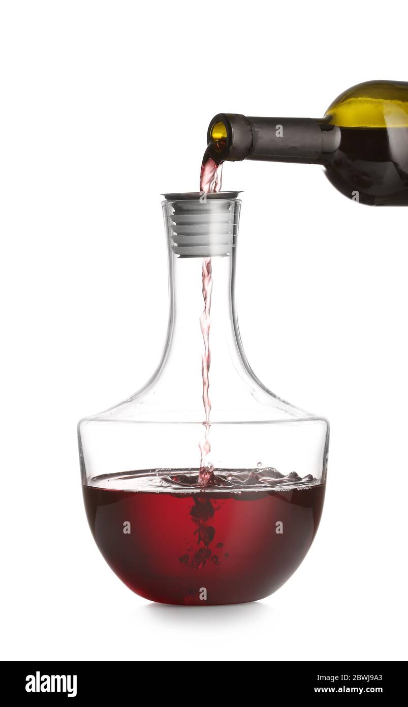 Pouring of wine from bottle into decanter on white background Stock