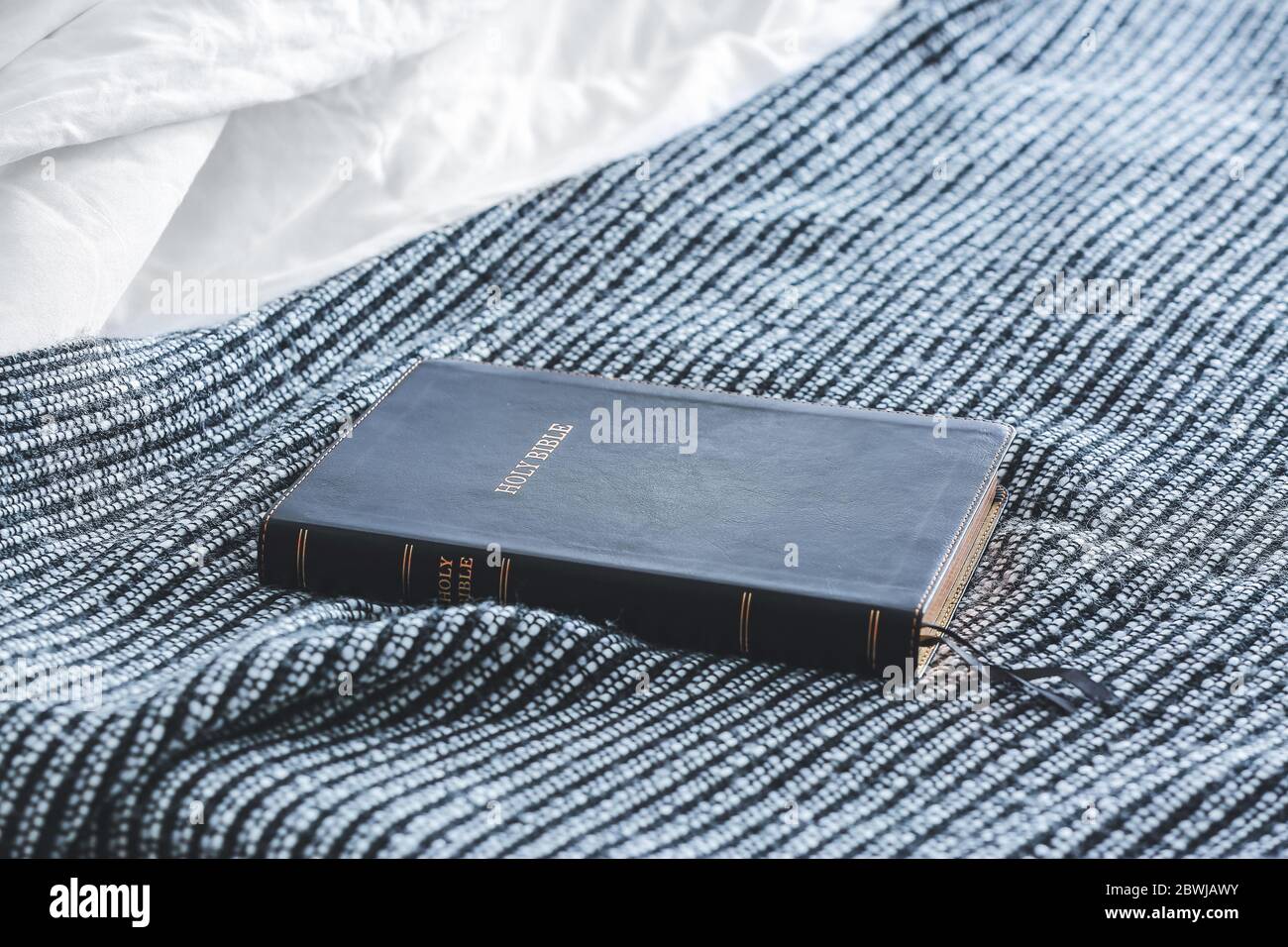 Holy Bible on bed in room Stock Photo - Alamy