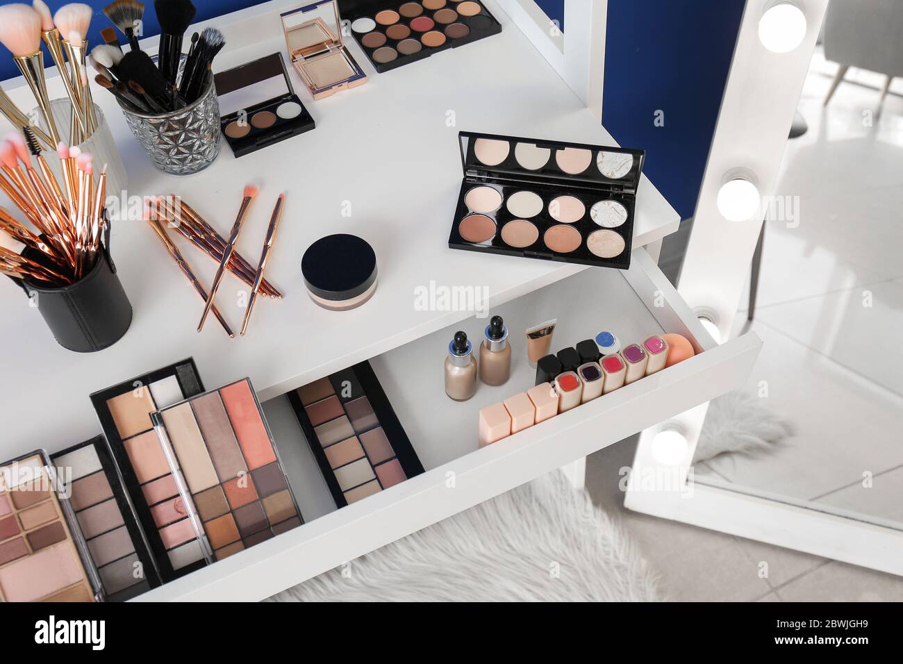 Table with makeup cosmetics in modern dressing room Stock Photo Alamy