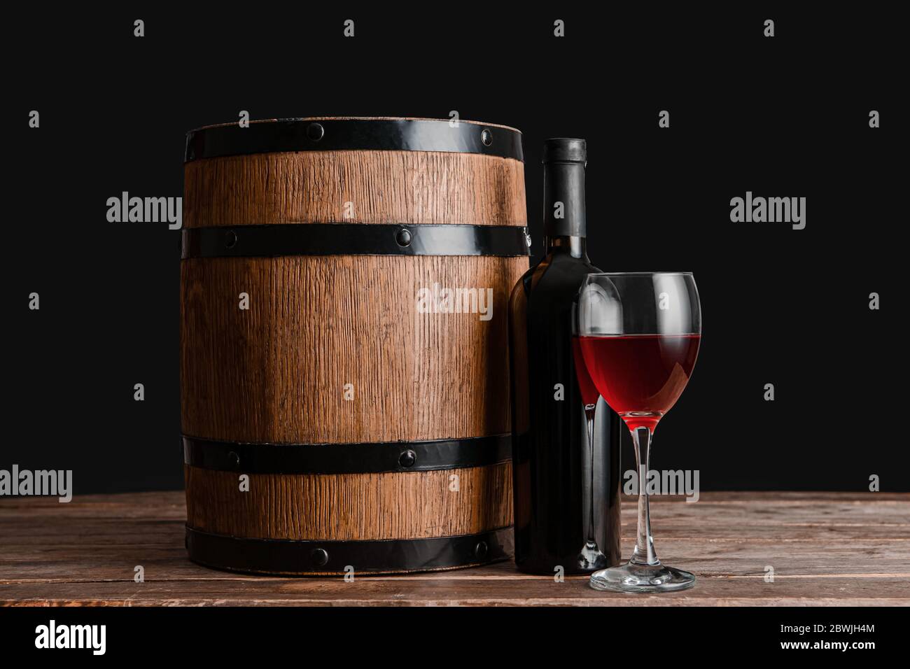 Wooden barrel, bottle and glass of wine on dark background Stock Photo ...