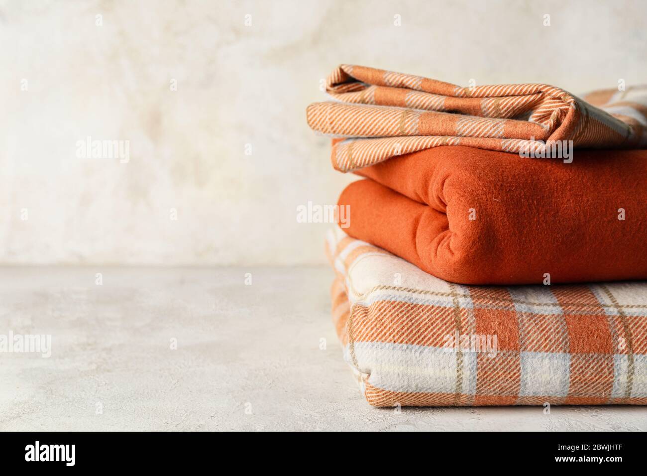 Stack of clean bed sheets on table Stock Photo