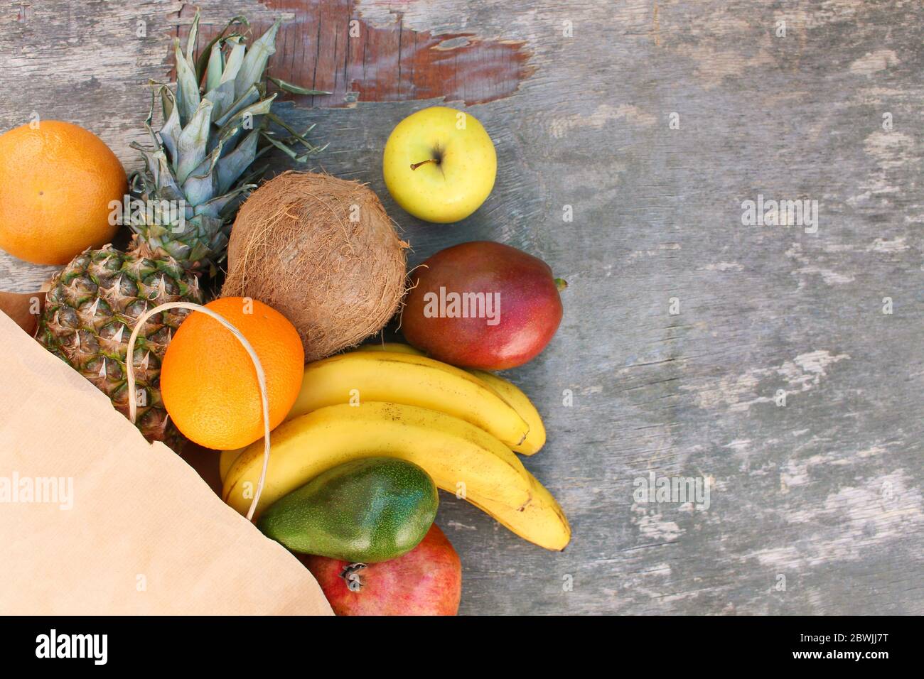Paper bag with fruits and vegetables on old wooden background. Top view ...