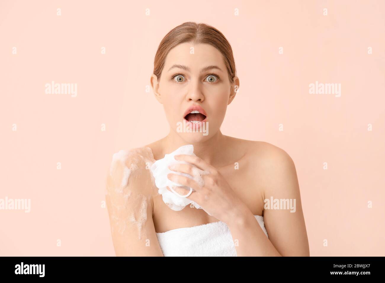 Shocked young woman taking shower on color background Stock Photo Alamy