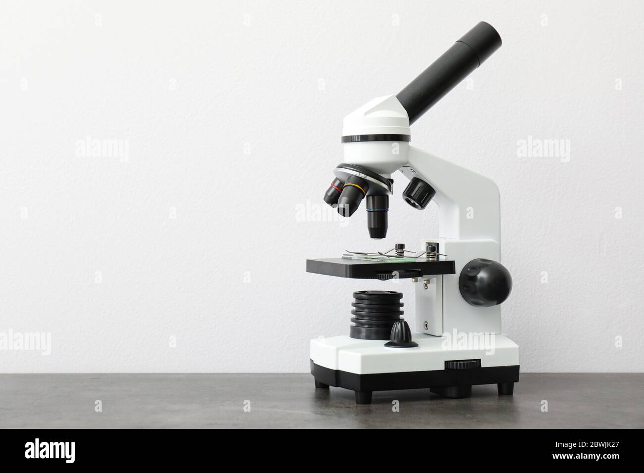 Modern microscope on table against light background Stock Photo - Alamy