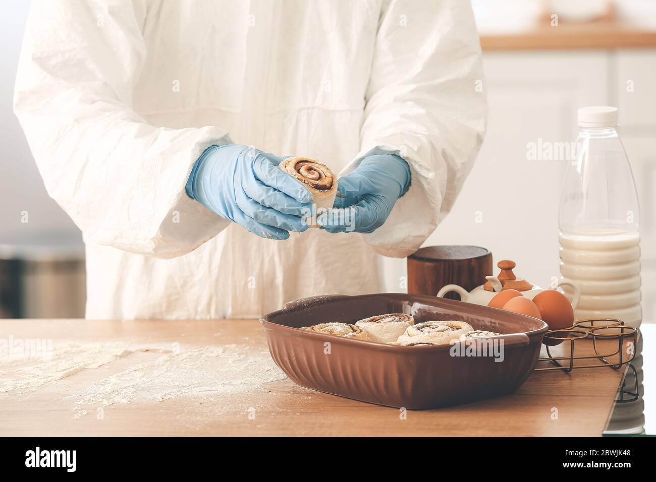 Woman in biohazard suit cooking in kitchen Stock Photo - Alamy