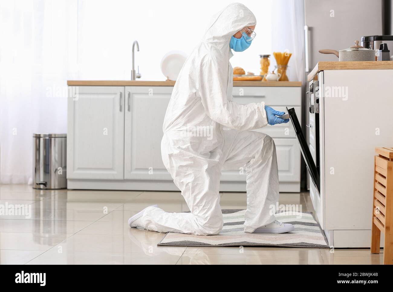 Woman in biohazard suit cooking in kitchen Stock Photo - Alamy