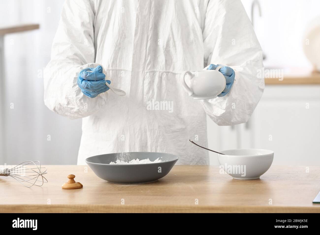 Woman in biohazard suit cooking in kitchen Stock Photo - Alamy