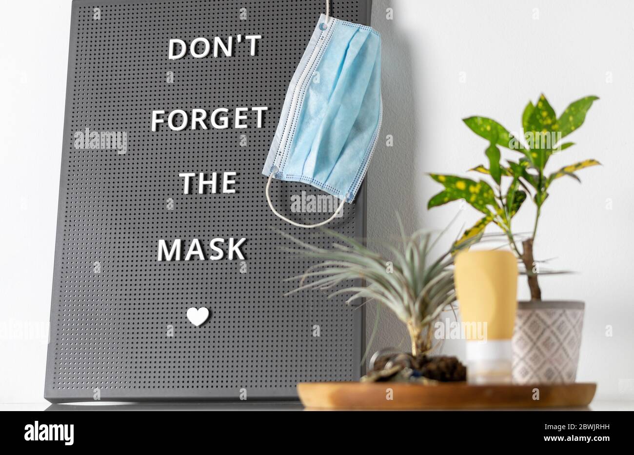 COVID-19 sign remembers to wear and at business stores. Message to the family to do not forget to take the medical mask to go outside during the coron Stock Photo