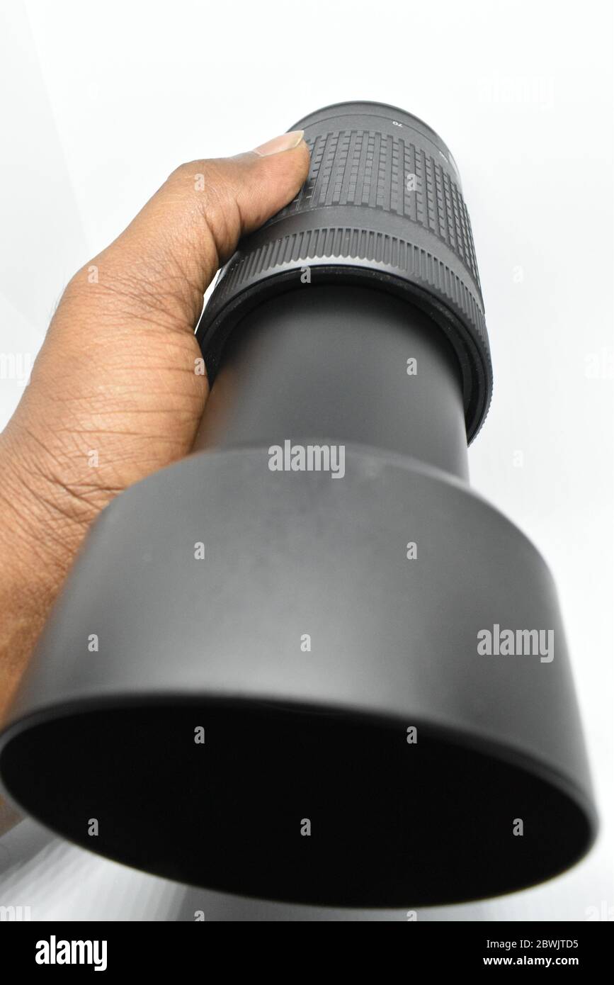 Closeup view of Nikon 70300mm camera lens holding with hand in white