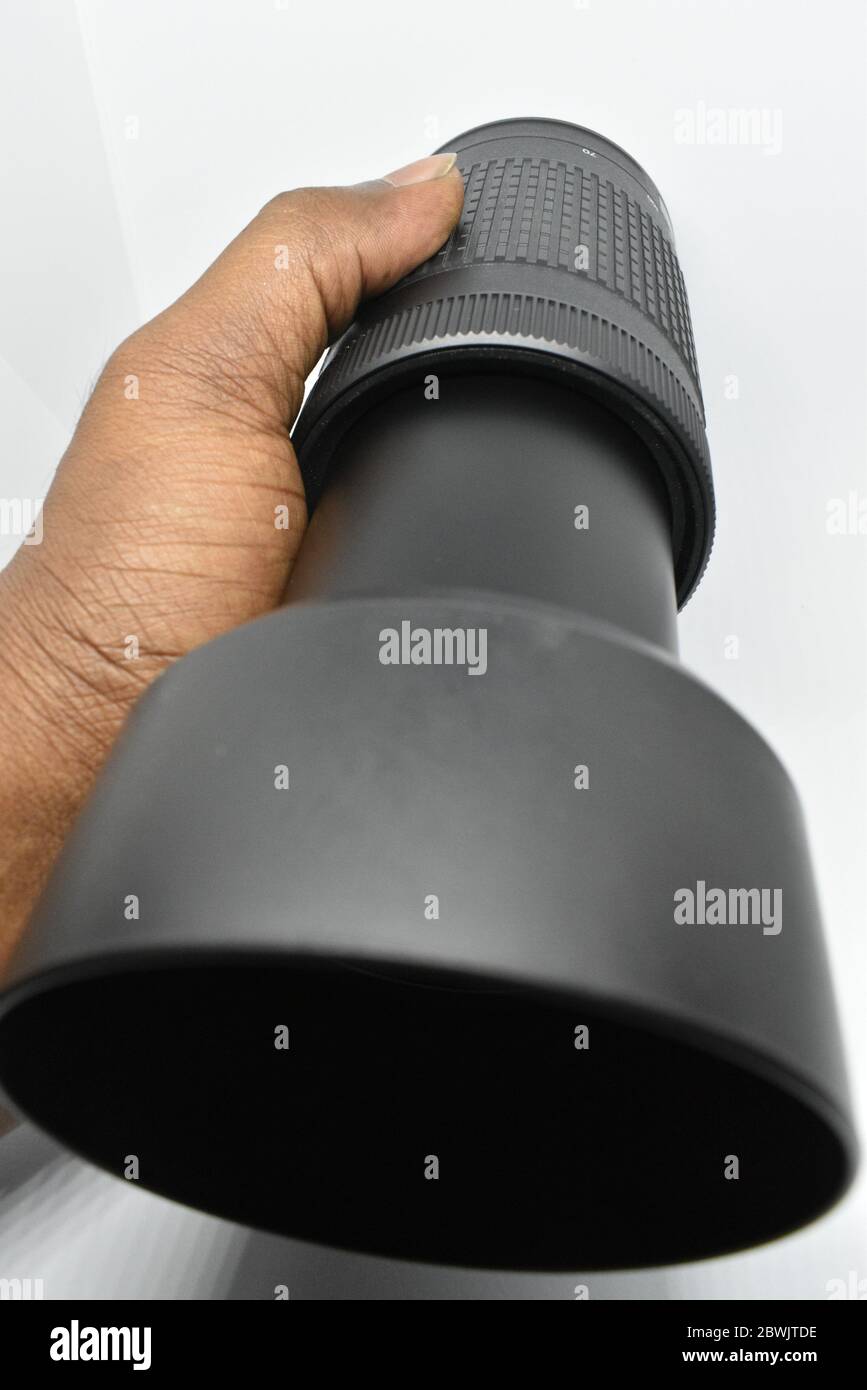 Closeup view of Nikon 70300mm camera lens holding with hand in white
