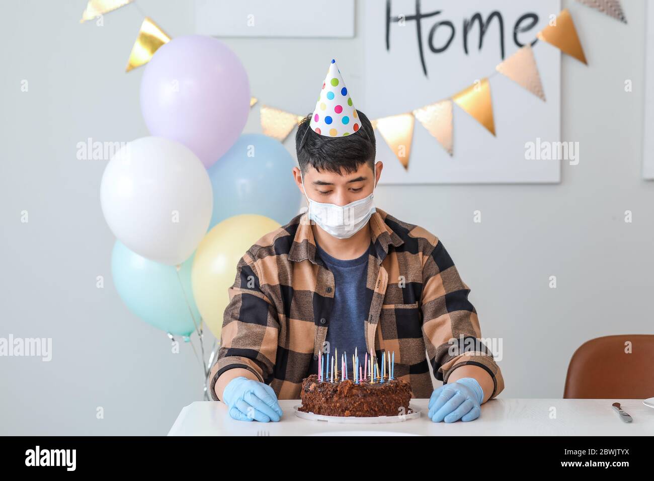 Sad Asian man celebrating Birthday without friends. Concept of epidemic Stock Photo