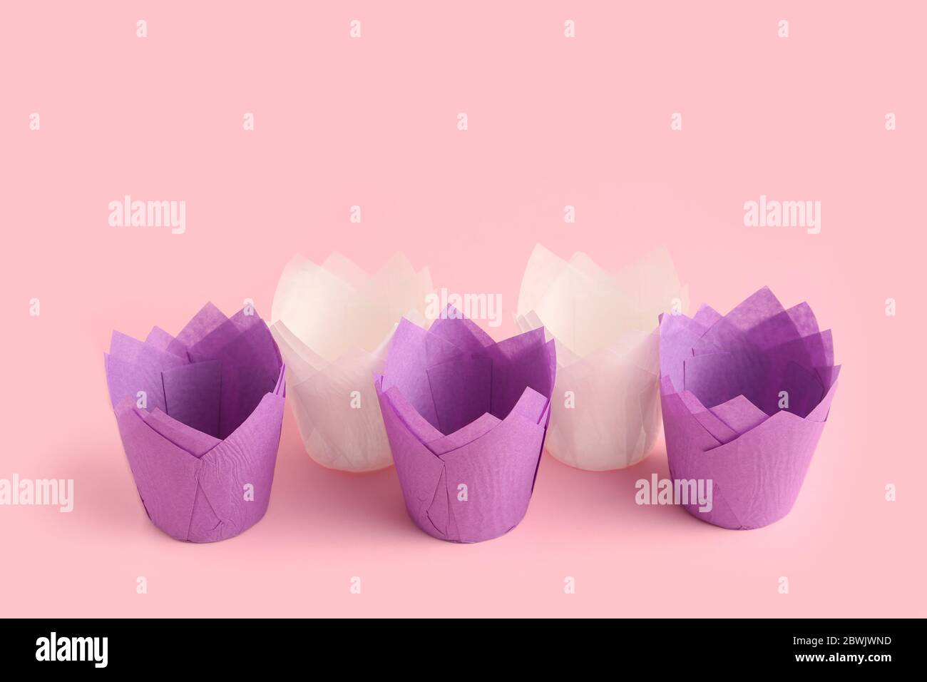Muffin baking cups on color background Stock Photo