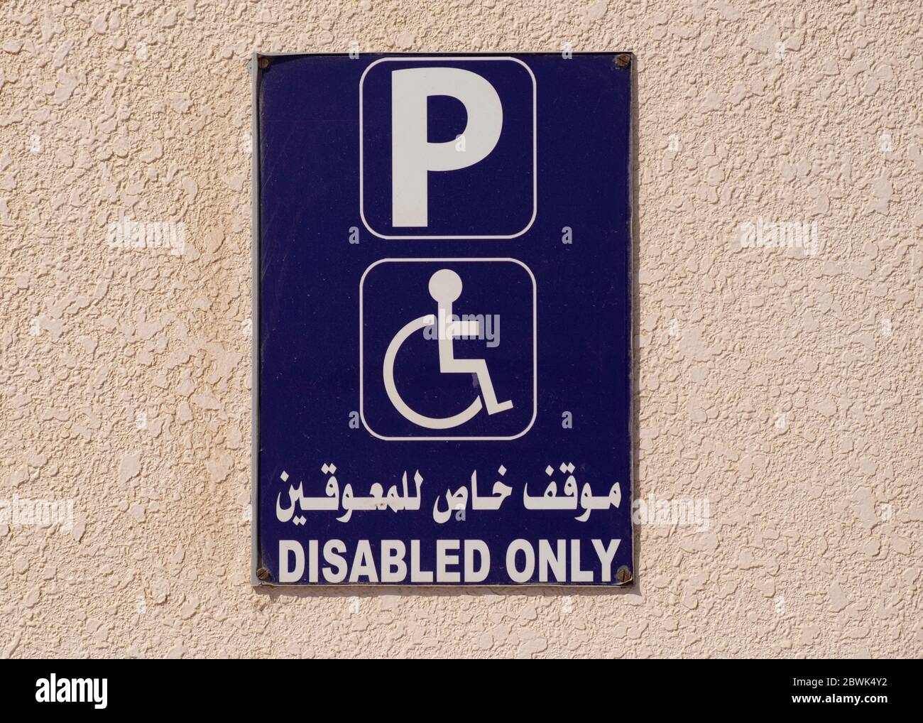 Close up of a parking sign for the disabled on a wall iof a mosque in Muscat, Sultanate of Oman. Stock Photo