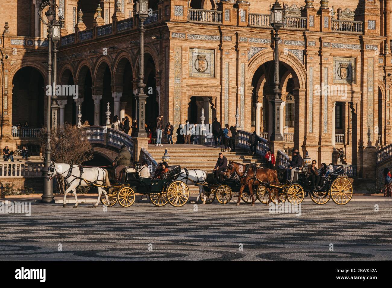 Seville, Spain - January 17, 2020: Horse-drawn carriages city tour on Plaza de España, a plaza in the Parque de María Luisa, in Seville, Spain, built Stock Photo