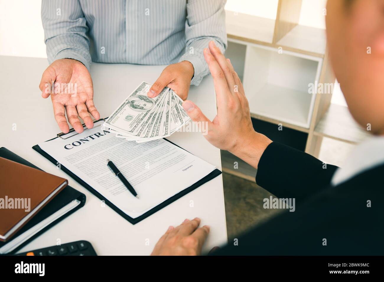 Business person refusing bribe given money by partner with anti bribery corruption concept. Stock Photo