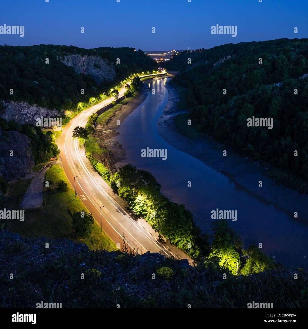 The A4 Portway road is lit at dusk in the Avon Gorge below Bristol's Clifton Suspension Bridge. Stock Photo