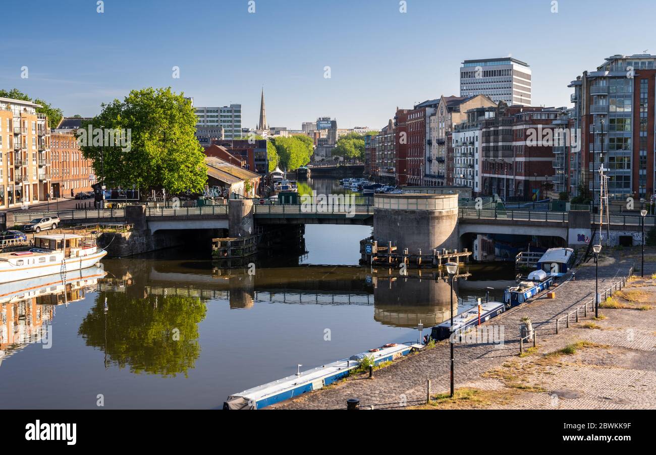 Bristol, England, UK - May 25, 2020: A cyclist crosses Redcliffe Bridge as down light falls on the quaysides and buildings of Bristol's Floating Harbo Stock Photo