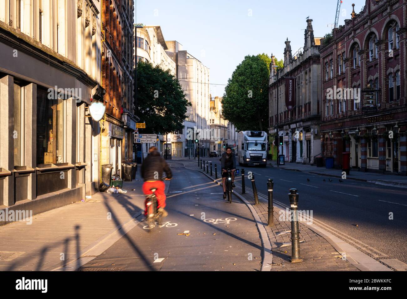 Bristol, England, UK - May 25, 2020: Two cyclists pass on a protected cycle track on Baldwin Street in Bristol's city centre. Stock Photo