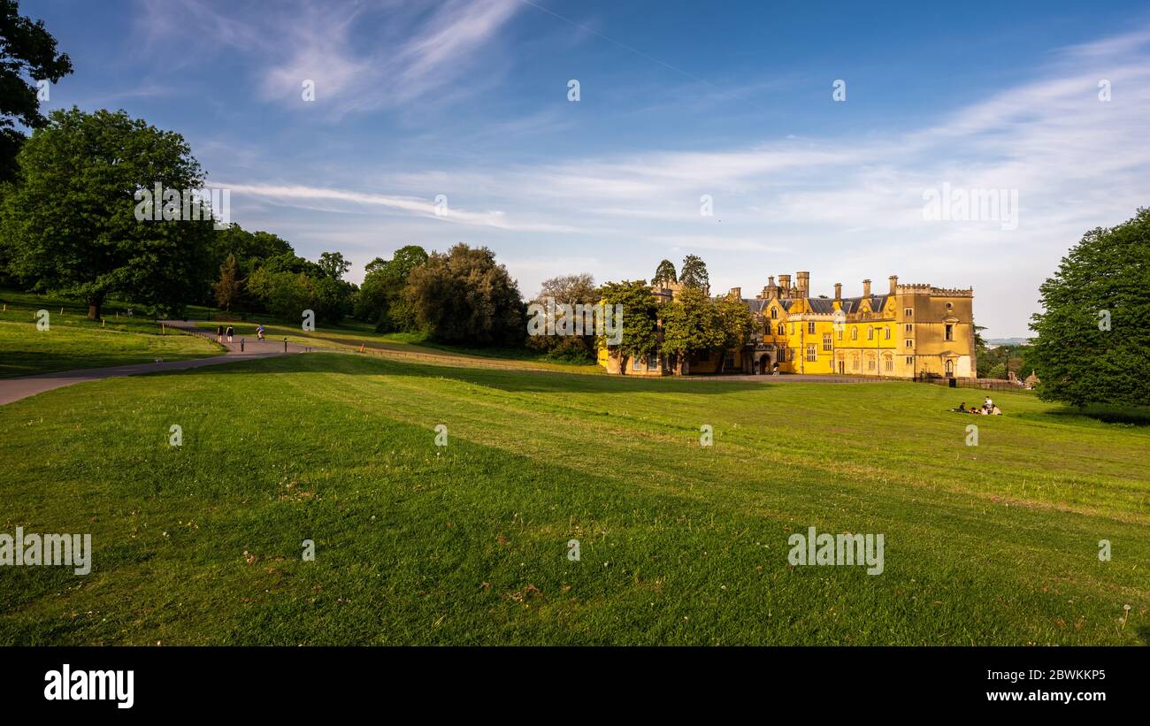 Bristol, England, UK - May 9, 2020: People walk, cycle and picnic in parkland beside Ashton Court mansion house in Bristol. Stock Photo