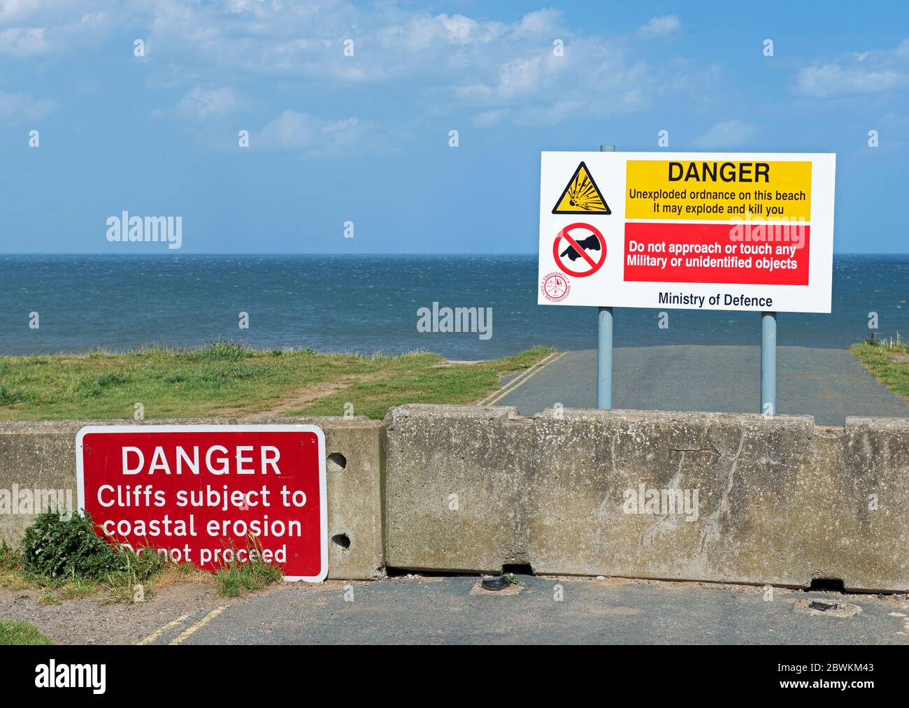 Signs warning against cliff erosion and unexploded ordnance, Aldbrough, East Yorkshire, England UK Stock Photo