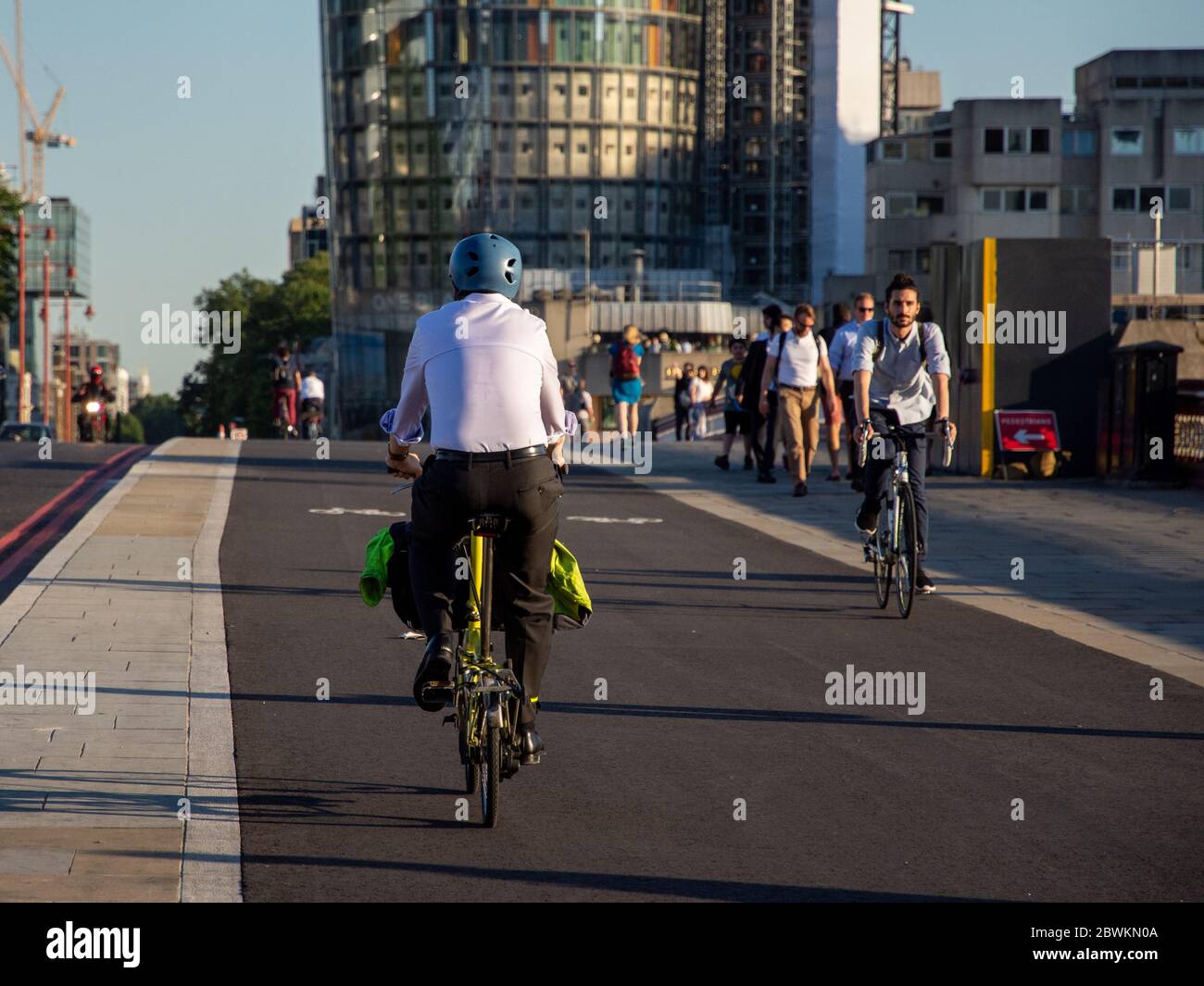 London, England, UK - July 19, 2016: Commuter cyclists in office clothes ride across Blackfriars Bridge on the newly opened Cycle Superhighway 6. Stock Photo
